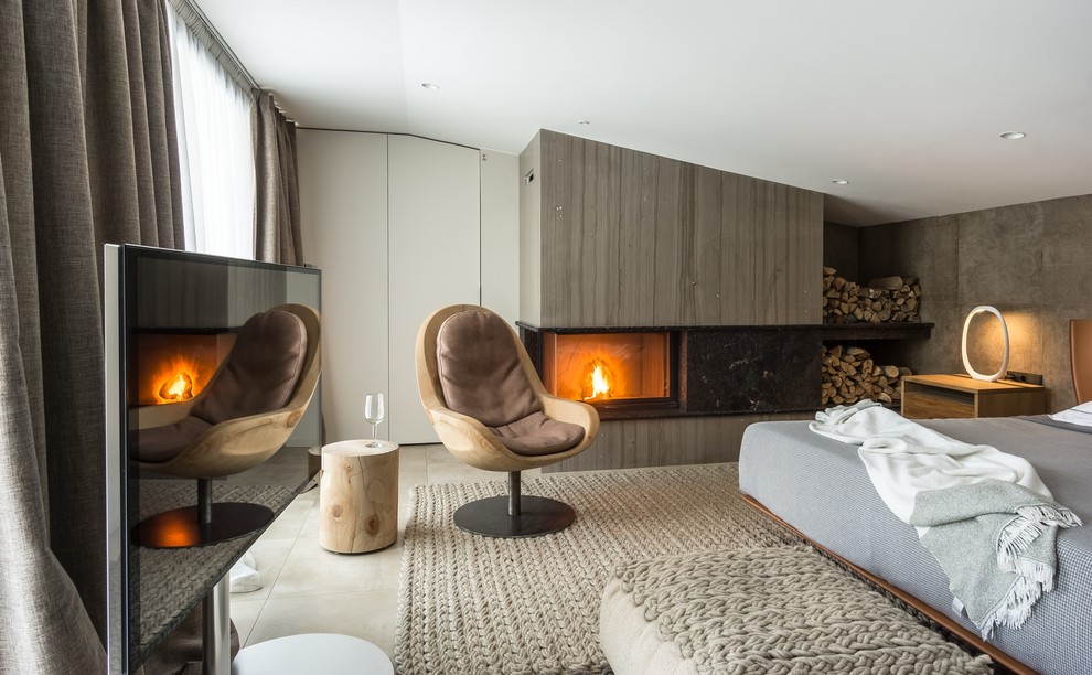 This is an example of a contemporary bedroom in Moscow with grey walls, a corner fireplace and beige floor.