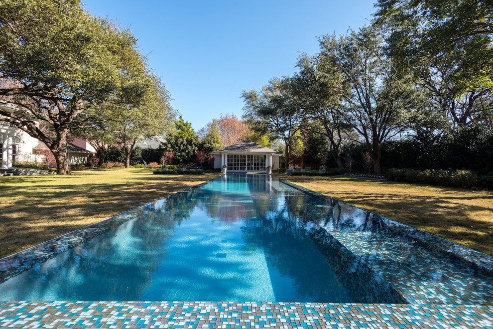 Huge transitional backyard rectangular infinity pool photo in Dallas