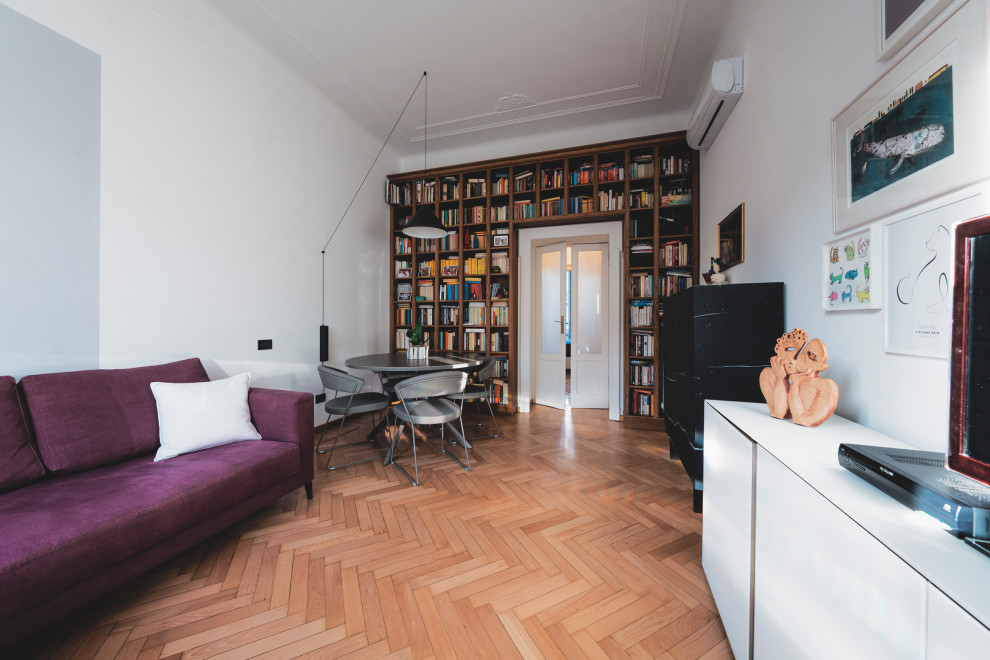 Photo of a medium sized bohemian enclosed games room in Milan with a reading nook, grey walls, light hardwood flooring, a freestanding tv and beige floors.