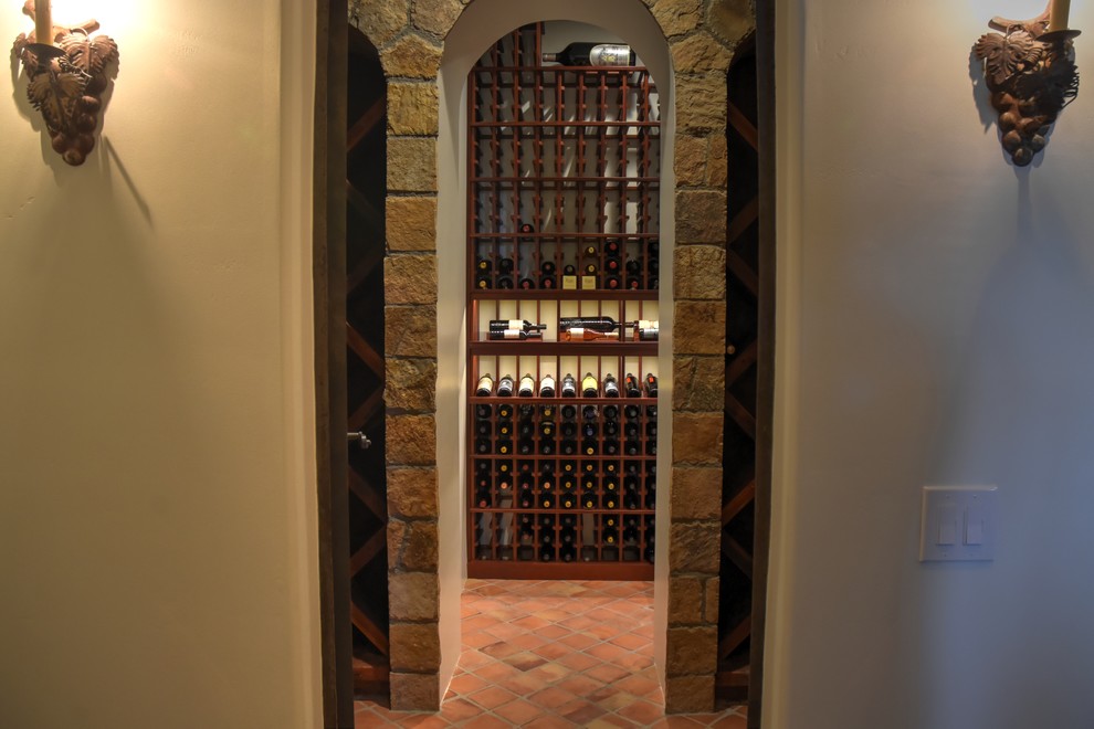 Mid-sized traditional wine cellar in San Diego with terra-cotta floors, display racks and orange floor.