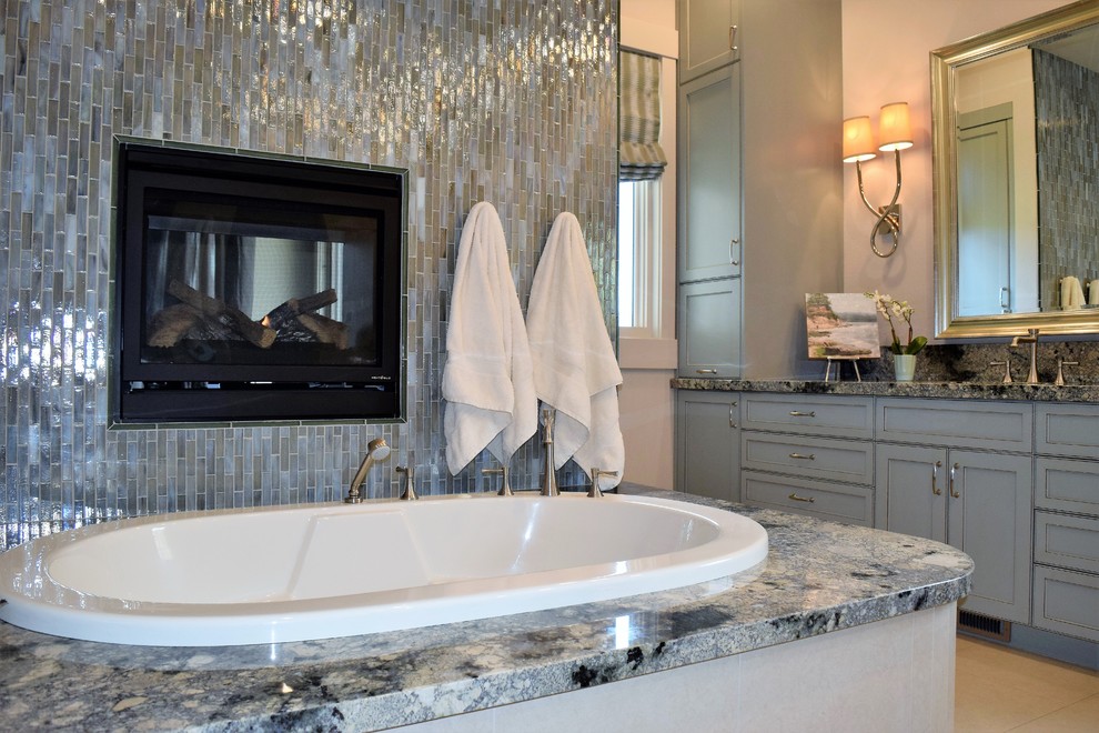 Inspiration for a large transitional master bathroom in Sacramento with recessed-panel cabinets, green cabinets, a hot tub, an open shower, a one-piece toilet, green tile, glass tile, beige walls, porcelain floors, an undermount sink and granite benchtops.