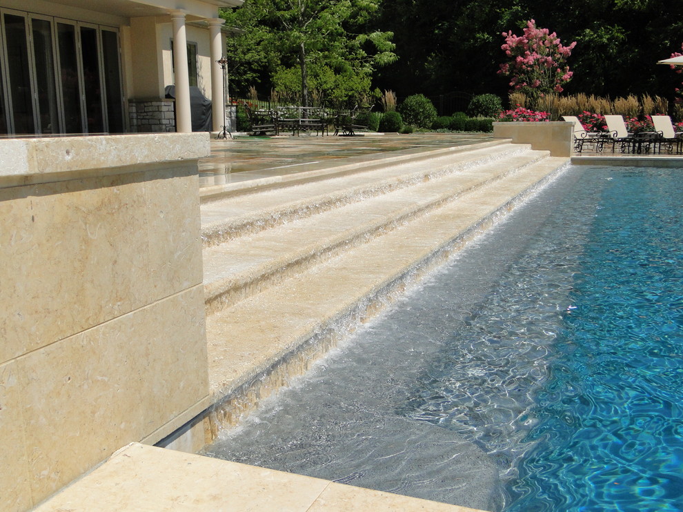 Photo of a large contemporary backyard rectangular lap pool in Philadelphia with natural stone pavers.