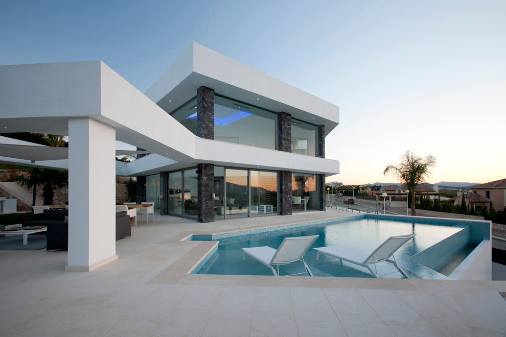 Design ideas for a contemporary backyard custom-shaped infinity pool in Alicante-Costa Blanca with tile.