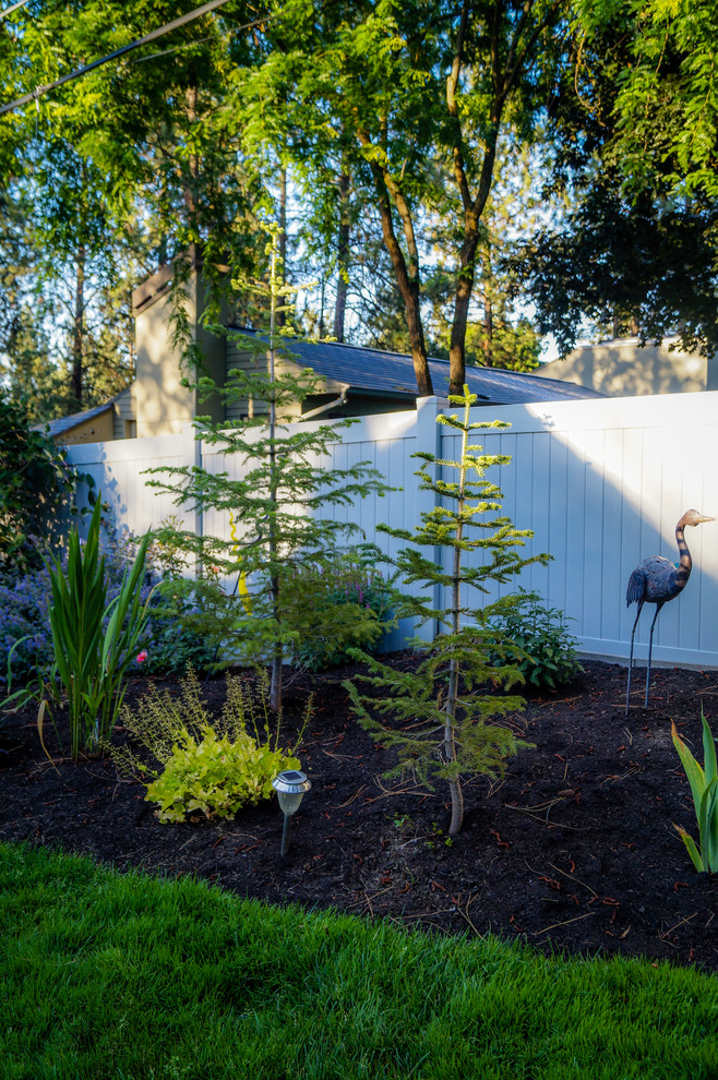 Photo of a mid-sized rustic partial sun backyard landscaping.