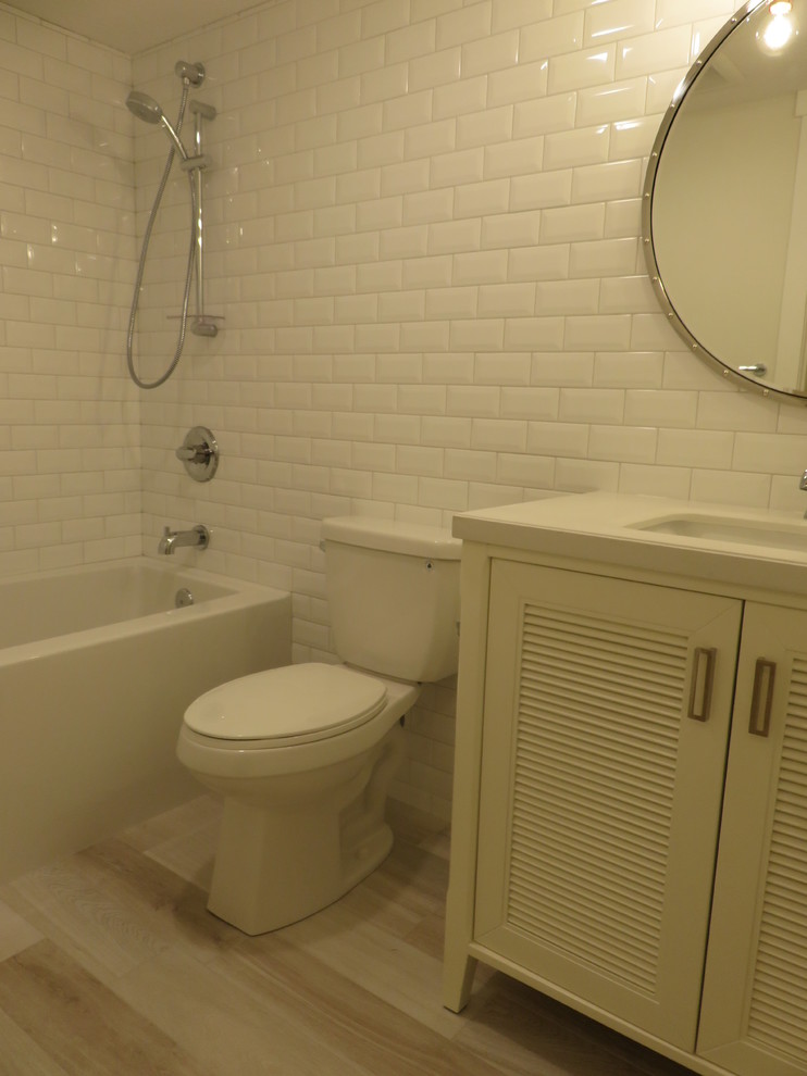 Alcove bathtub - small transitional kids' white tile and subway tile ceramic tile and gray floor alcove bathtub idea in Calgary with louvered cabinets, white cabinets, a two-piece toilet, white walls, an undermount sink and quartzite countertops