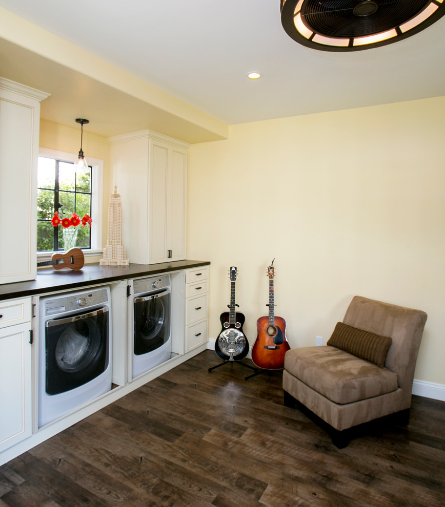 This is an example of a mid-sized transitional u-shaped utility room in San Francisco with recessed-panel cabinets, white cabinets, quartz benchtops, linoleum floors, a concealed washer and dryer and beige walls.