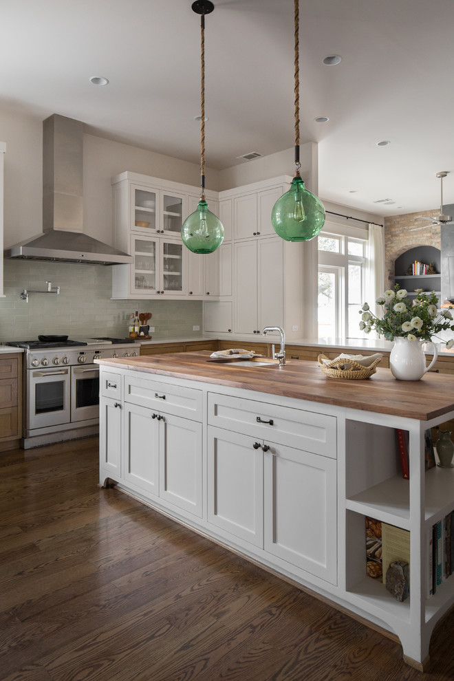 Transitional dark wood floor and brown floor kitchen photo in Houston with shaker cabinets, green backsplash, ceramic backsplash, stainless steel appliances, an island, white cabinets, wood countertops and brown countertops