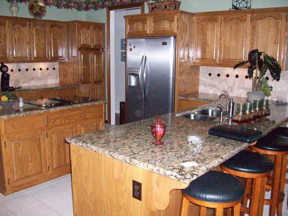 Kitchen - kitchen idea with beaded inset cabinets, light wood cabinets, a double-bowl sink, beige backsplash, stainless steel appliances and an island