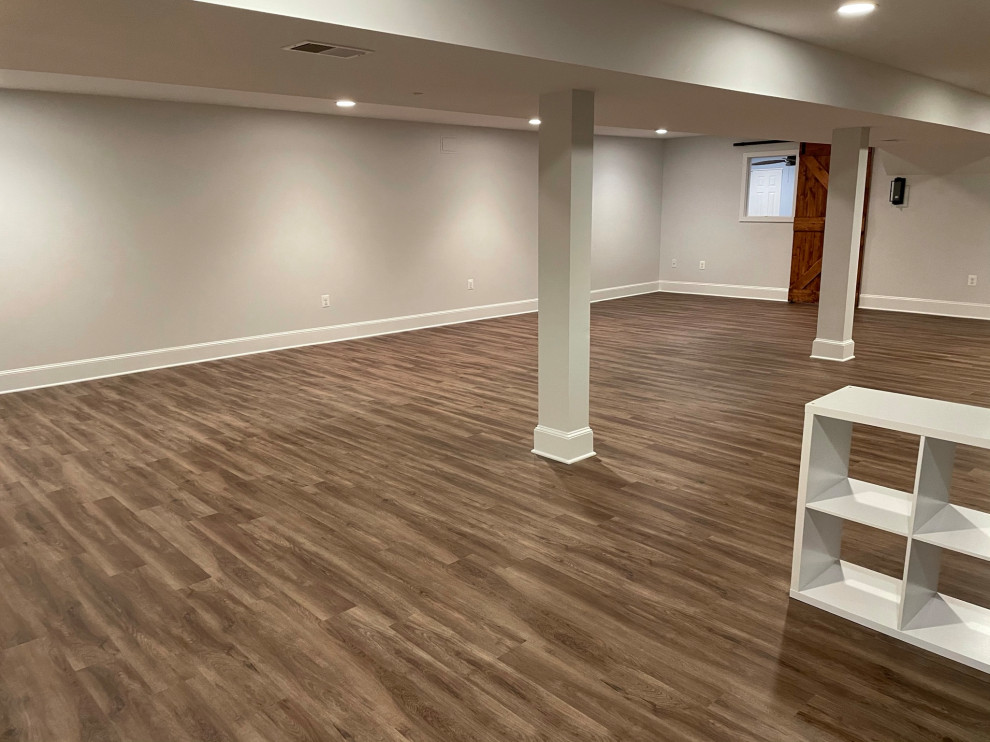 Idéer för att renovera en stor källare ovan mark, med beige väggar, vinylgolv och brunt golv