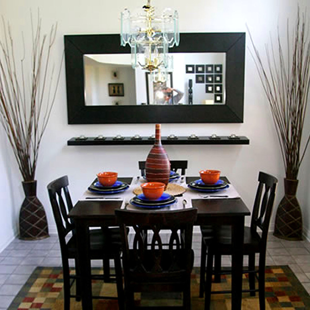 Photo of a small traditional open plan dining in Los Angeles with white walls, ceramic floors, no fireplace and grey floor.