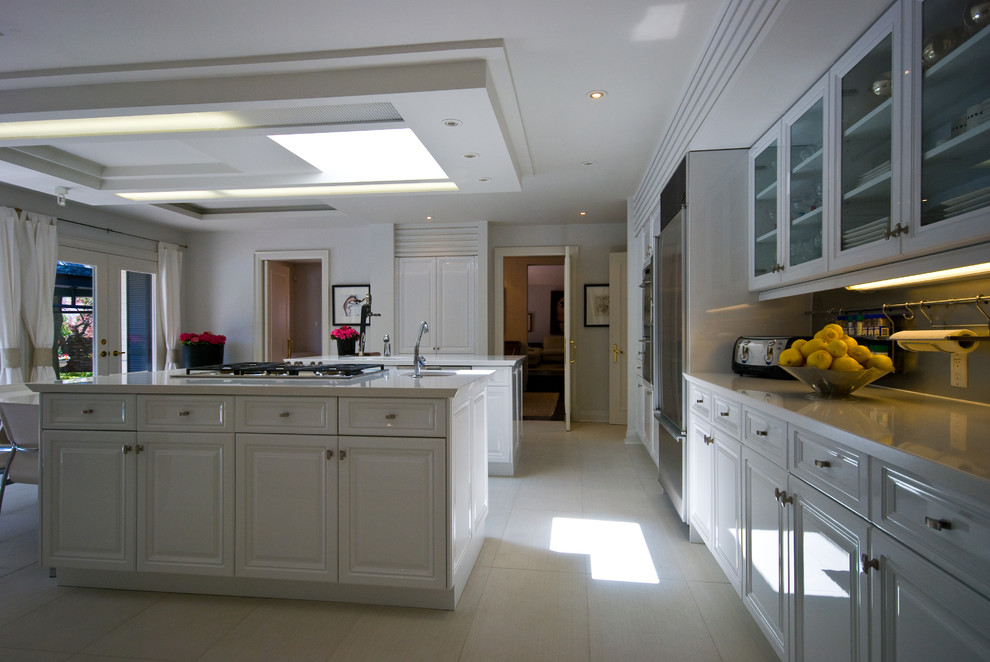 Example of a large transitional u-shaped marble floor eat-in kitchen design in Toronto with a single-bowl sink, raised-panel cabinets, white cabinets, solid surface countertops, stainless steel appliances and a peninsula