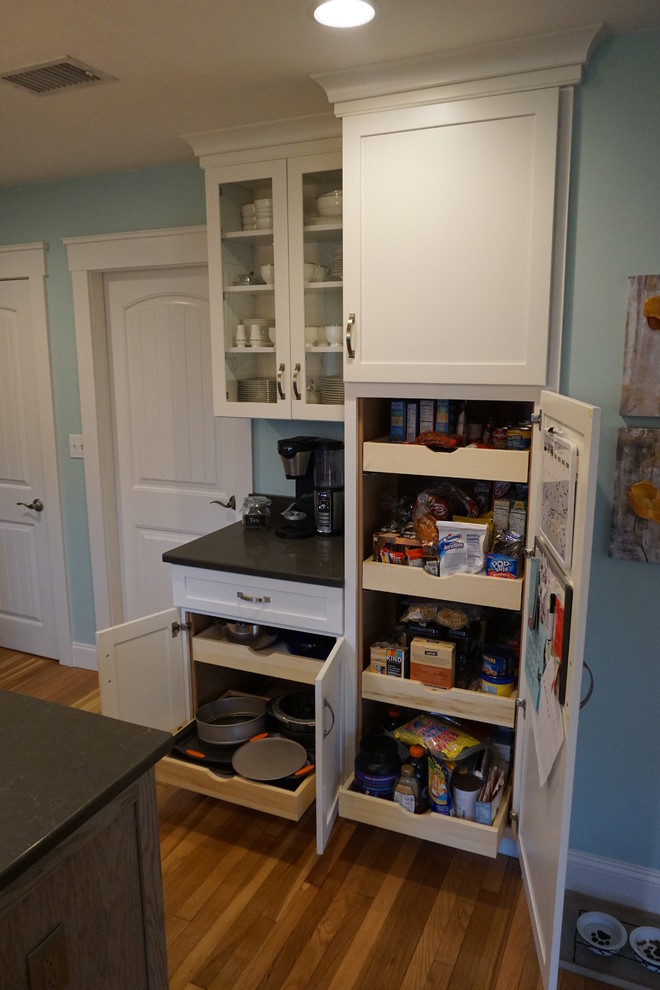 Mid-sized transitional u-shaped medium tone wood floor eat-in kitchen photo in Boston with an undermount sink, shaker cabinets, gray cabinets, quartz countertops, black backsplash, stainless steel appliances and an island