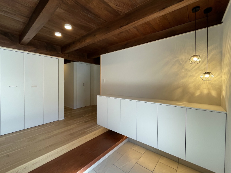 Ejemplo de hall de estilo zen de tamaño medio con paredes blancas, suelo de baldosas de cerámica, puerta de madera oscura, suelo gris y madera