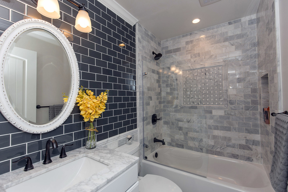 Small contemporary bathroom in Los Angeles with raised-panel cabinets, white cabinets, an alcove tub, a shower/bathtub combo, a two-piece toilet, white tile, stone tile, grey walls, marble floors, an undermount sink and marble benchtops.