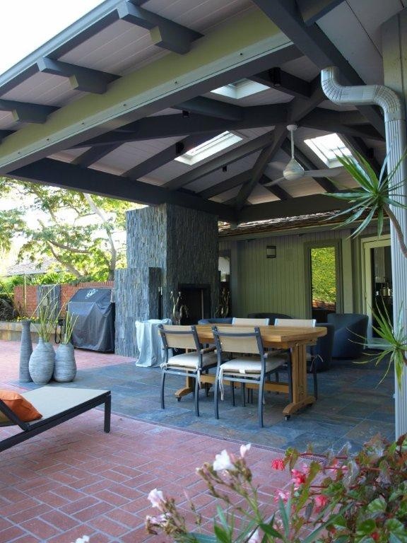 Inspiration for a large asian backyard patio in San Diego with a fire feature, tile and a roof extension.