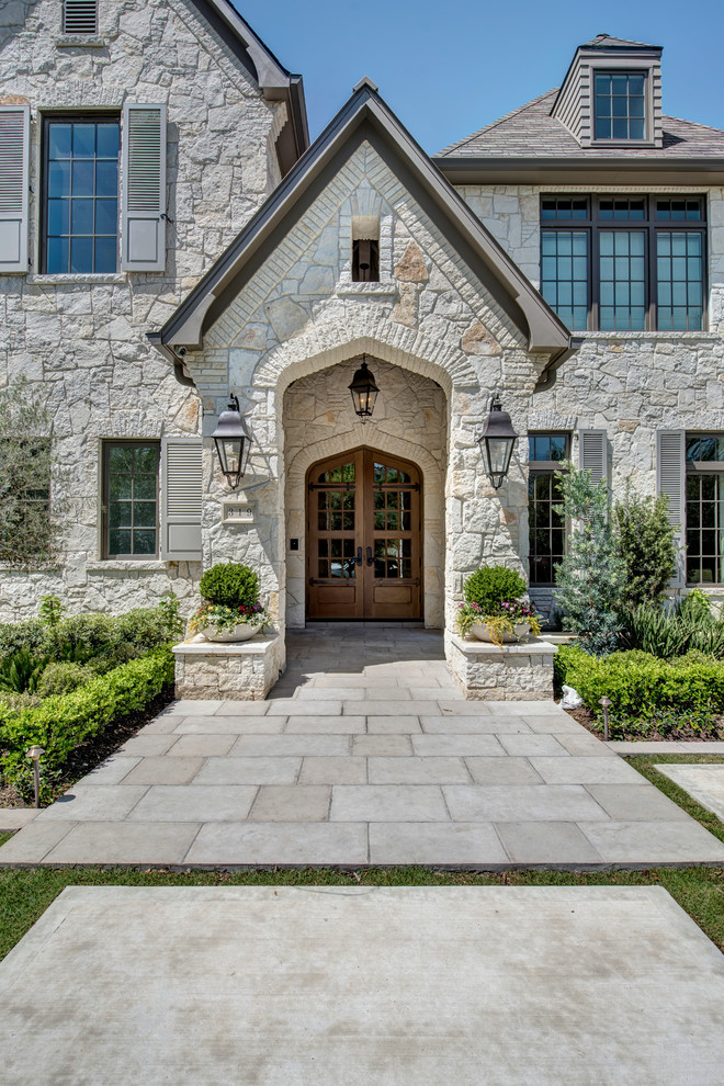 This is an example of a mid-sized mediterranean front door in Houston with concrete floors, a double front door and a medium wood front door.