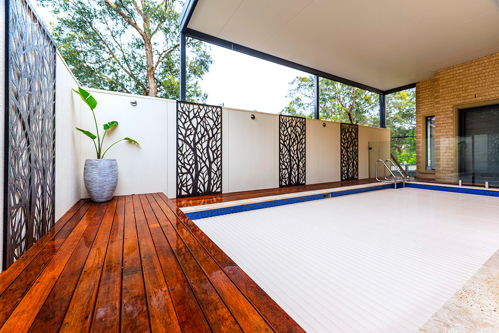 Mid-sized modern side yard rectangular lap pool in Melbourne with decking.