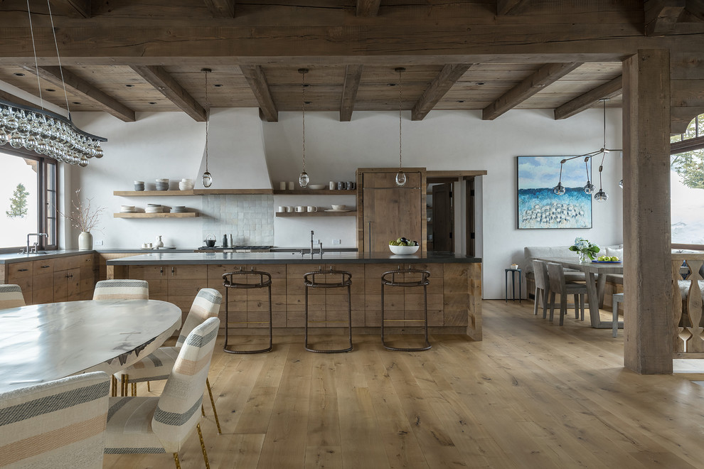 Photo of a country l-shaped eat-in kitchen in Other with an undermount sink, flat-panel cabinets, medium wood cabinets, grey splashback, mosaic tile splashback, panelled appliances, light hardwood floors, with island, beige floor and grey benchtop.