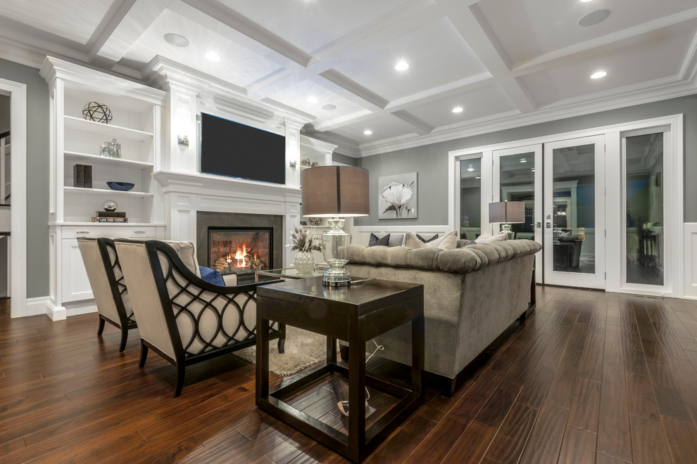 Inspiration for a large transitional enclosed family room in Edmonton with grey walls, dark hardwood floors, a standard fireplace and a wall-mounted tv.
