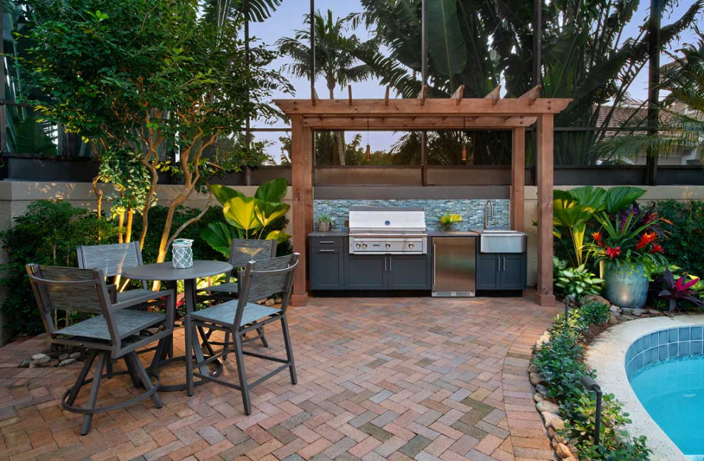 Large island style backyard brick patio photo in Miami