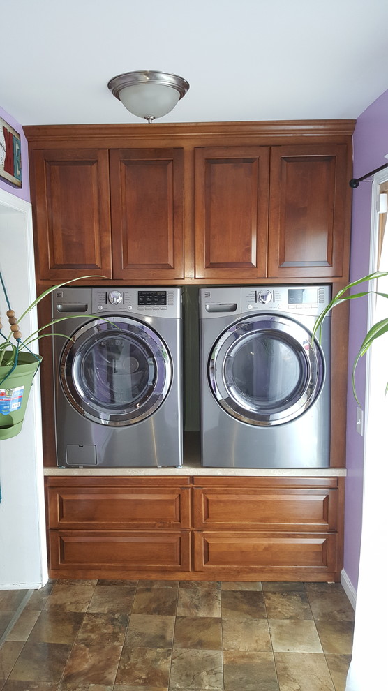 Large traditional single-wall utility room in Philadelphia with raised-panel cabinets, medium wood cabinets, laminate benchtops and a side-by-side washer and dryer.