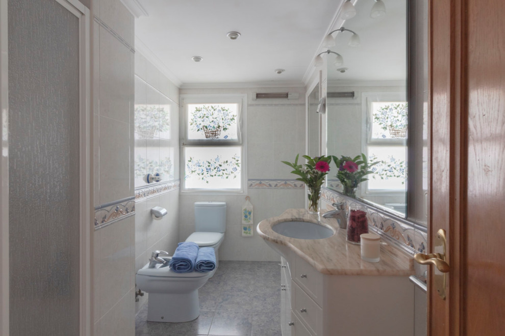 Immagine di una stanza da bagno stile marino con pareti bianche e top beige