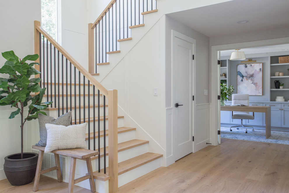 Staircase - large transitional wooden u-shaped mixed material railing and wall paneling staircase idea in Seattle with painted risers