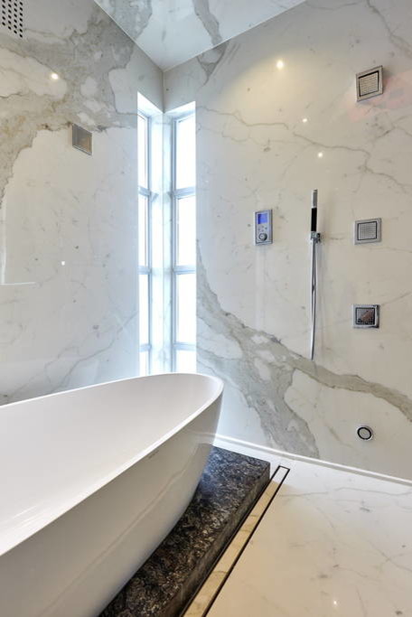 Photo of a large modern master bathroom in Toronto with flat-panel cabinets, dark wood cabinets, a freestanding tub, an open shower, a bidet, multi-coloured tile, stone tile, multi-coloured walls, porcelain floors, an undermount sink and marble benchtops.