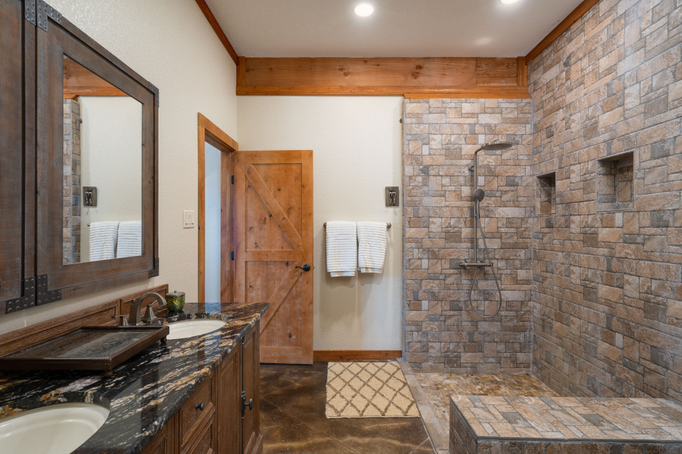 This is an example of an expansive bathroom in Other with concrete floors, brown floor, exposed beam, furniture-like cabinets, brown cabinets, an open shower, stone tile, white walls, a drop-in sink, granite benchtops, an open shower, a shower seat, a double vanity and a floating vanity.