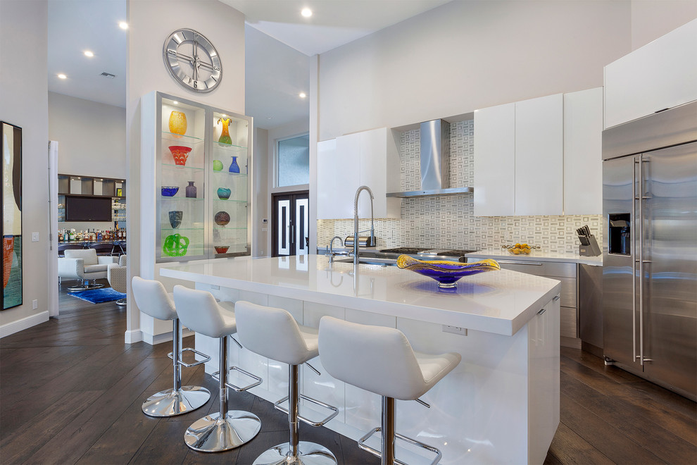 Inspiration for an expansive contemporary galley eat-in kitchen in Miami with an undermount sink, flat-panel cabinets, white cabinets, quartzite benchtops, multi-coloured splashback, mosaic tile splashback, stainless steel appliances, dark hardwood floors, with island and brown floor.