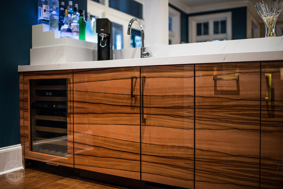 Design ideas for a mid-sized modern u-shaped wet bar in Tampa with an undermount sink, flat-panel cabinets, medium wood cabinets, medium hardwood floors and white benchtop.