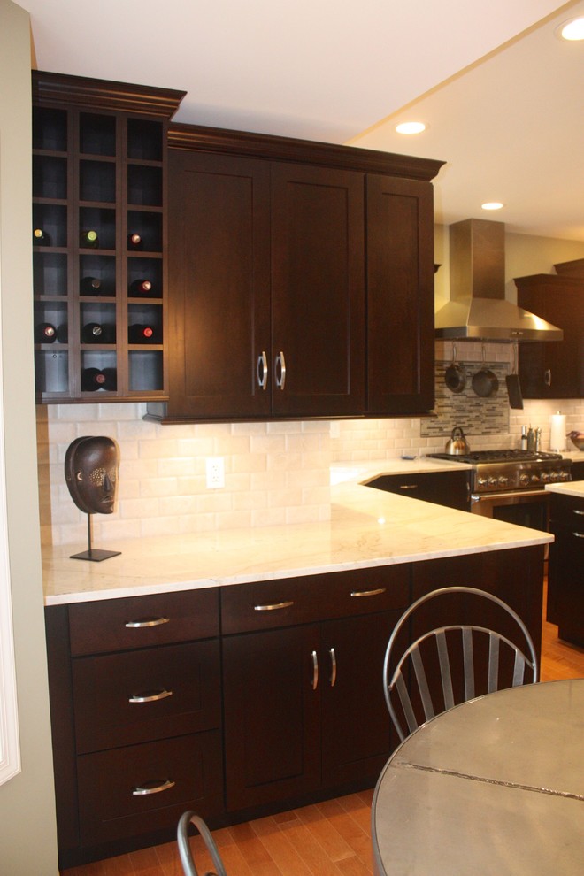 Example of a mid-sized trendy u-shaped medium tone wood floor kitchen design with shaker cabinets, dark wood cabinets, white backsplash, stainless steel appliances and an island