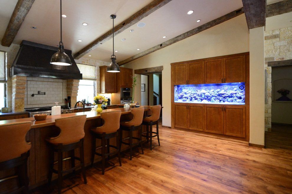 Photo of a large transitional single-wall open plan kitchen in Dallas with dark wood cabinets, wood benchtops, dark hardwood floors, with island and brown floor.