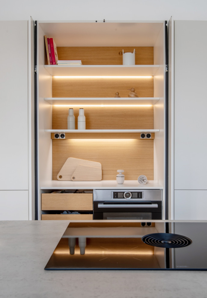 Foto de cocina escandinava de tamaño medio abierta con armarios con paneles lisos, puertas de armario blancas, encimeras grises y barras de cocina