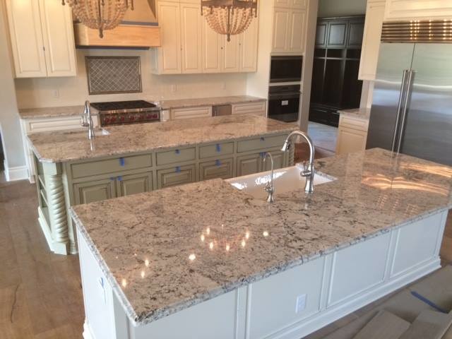 Inspiration for a large transitional l-shaped medium tone wood floor and brown floor open concept kitchen remodel in Austin with a farmhouse sink, raised-panel cabinets, white cabinets, granite countertops, stainless steel appliances, two islands and gray countertops
