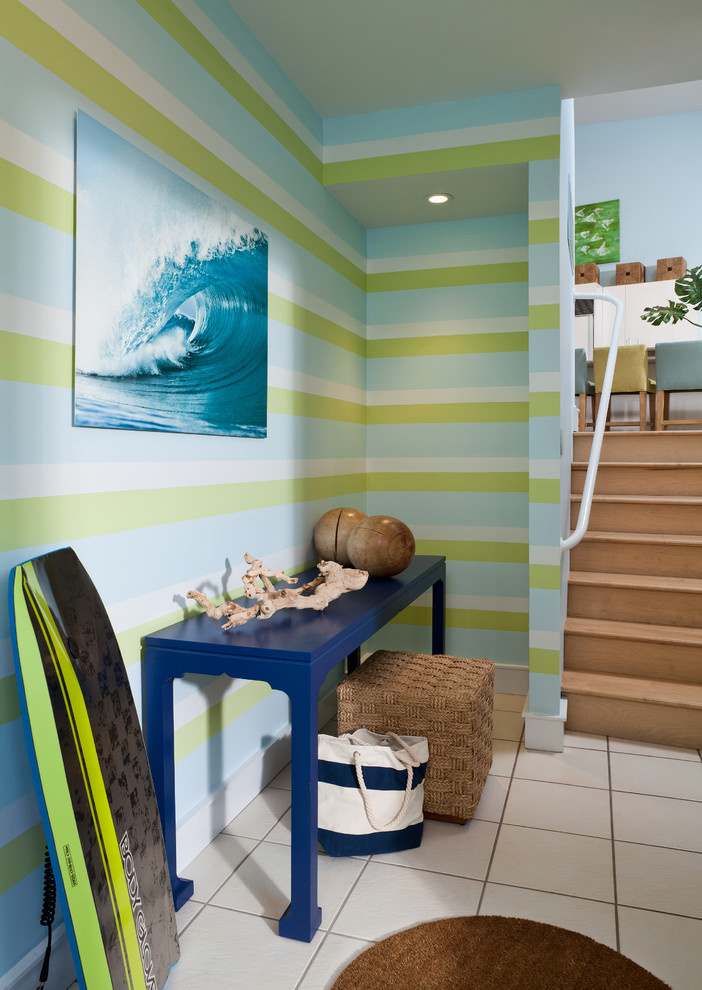 Photo of a mid-sized beach style foyer in New York with multi-coloured walls, ceramic floors, a double front door, a blue front door and white floor.