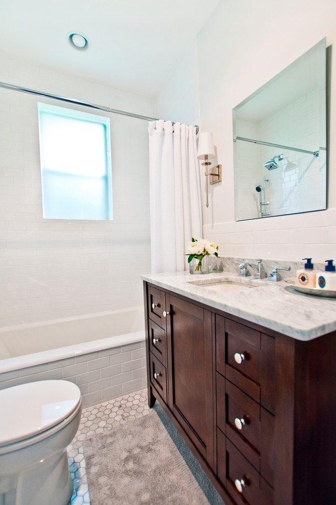 Photo of a small transitional bathroom in Nashville with shaker cabinets, dark wood cabinets, an alcove tub, a shower/bathtub combo, a two-piece toilet, white tile, white walls, marble floors, an undermount sink, marble benchtops, subway tile, multi-coloured floor, a shower curtain and multi-coloured benchtops.