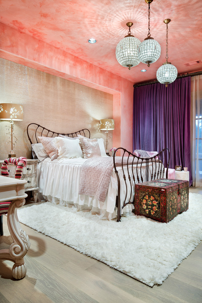 This is an example of a mediterranean bedroom in Houston with pink walls and medium hardwood floors.