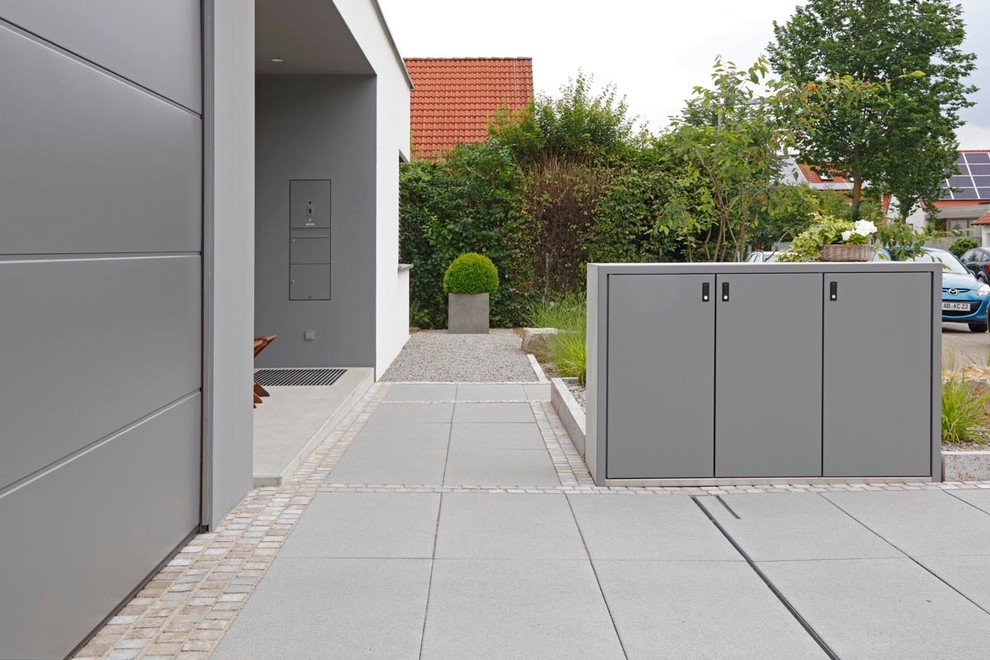 Photo of a mid-sized contemporary front yard full sun driveway for fall in Frankfurt with a garden path and gravel.