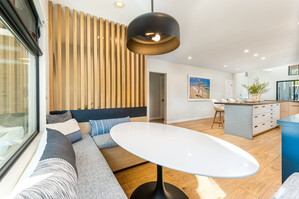 Ejemplo de comedor contemporáneo de tamaño medio con con oficina, paredes grises y suelo de madera en tonos medios