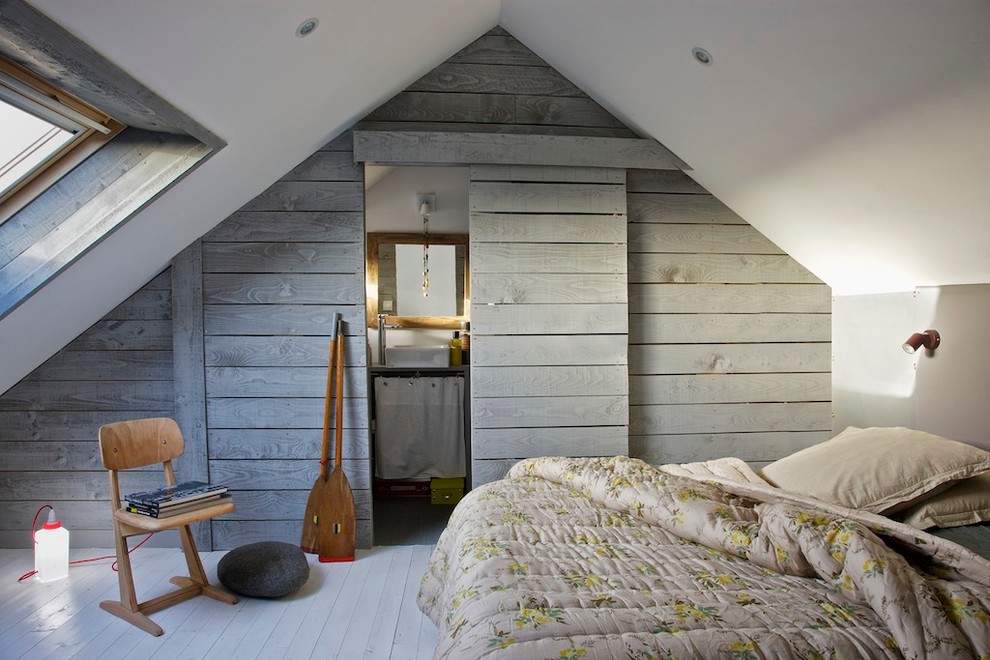This is an example of a small beach style bedroom in Rennes with painted wood floors.