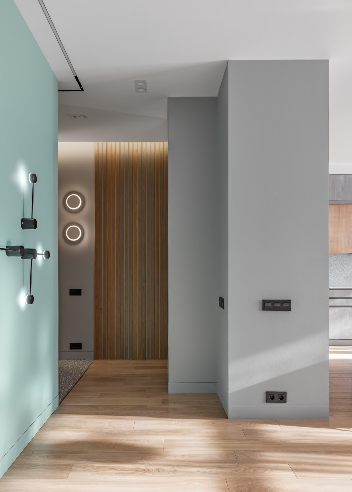 Cette image montre un couloir design de taille moyenne avec un mur vert, un sol en bois brun et un sol marron.