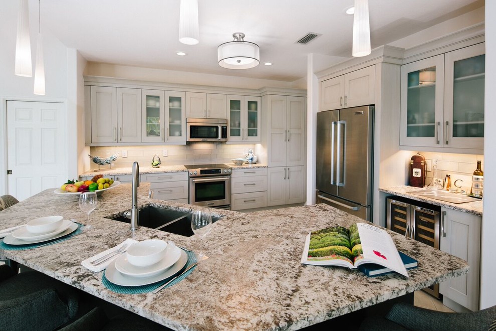 Example of a large transitional l-shaped travertine floor and beige floor eat-in kitchen design in Miami with an undermount sink, recessed-panel cabinets, dark wood cabinets, quartz countertops, beige backsplash, matchstick tile backsplash, stainless steel appliances and two islands