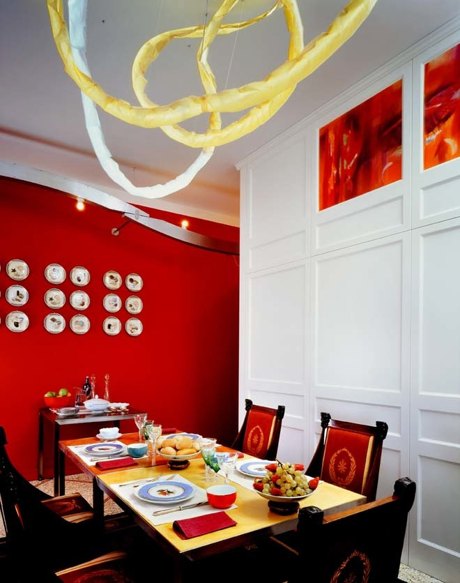 Cette photo montre une grande salle à manger ouverte sur le salon chic avec un mur rouge, un sol en marbre et boiseries.