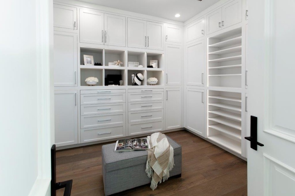 Photo of a large beach style women's dressing room in Orange County with shaker cabinets, white cabinets, dark hardwood floors and brown floor.