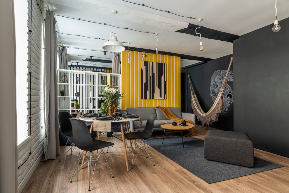 Foto di un piccolo soggiorno scandinavo con pareti gialle, pavimento beige, travi a vista, pareti in legno e pavimento in laminato