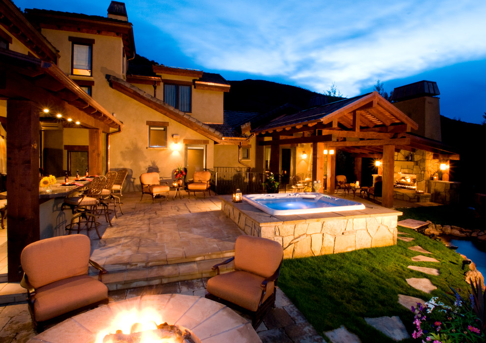 Inspiration for a large rustic backyard concrete paver patio kitchen remodel in Denver with a roof extension