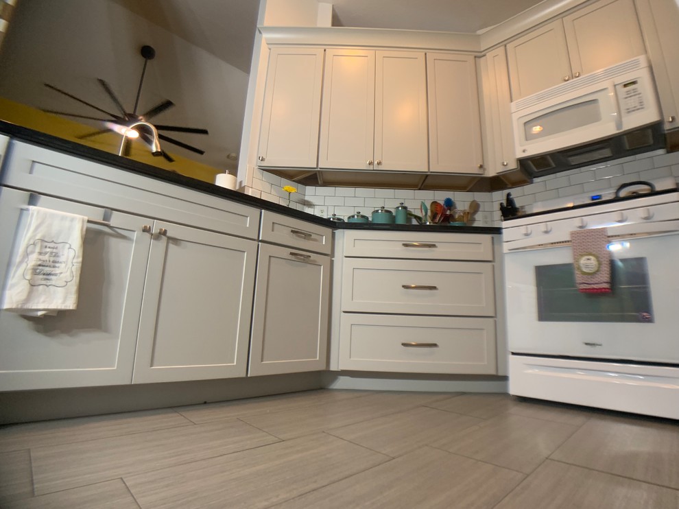 Example of a small transitional u-shaped ceramic tile eat-in kitchen design in Orlando with an undermount sink, shaker cabinets, gray cabinets, granite countertops, subway tile backsplash and no island