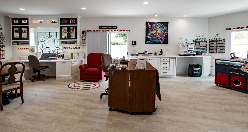 Idéer för ett stort klassiskt hobbyrum, med vita väggar, vinylgolv, ett inbyggt skrivbord och brunt golv