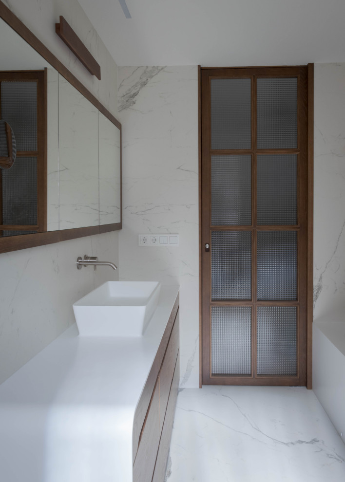 Aménagement d'une grande salle de bain principale éclectique avec un placard en trompe-l'oeil, des portes de placard blanches, une baignoire encastrée, un combiné douche/baignoire, WC à poser, un carrelage blanc, un mur blanc, un sol en carrelage de céramique, un lavabo intégré, un plan de toilette en surface solide, un sol blanc, une cabine de douche à porte battante, un plan de toilette blanc, une fenêtre, meuble simple vasque et meuble-lavabo encastré.